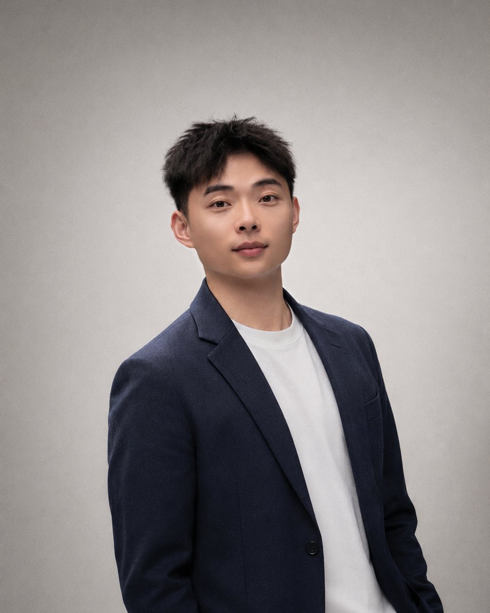 Yan 的肖像照，深蓝西装配白色 T 恤